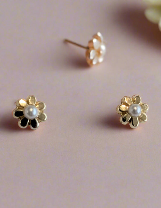 Gold flower-shaped earrings with pearl centers on a white background