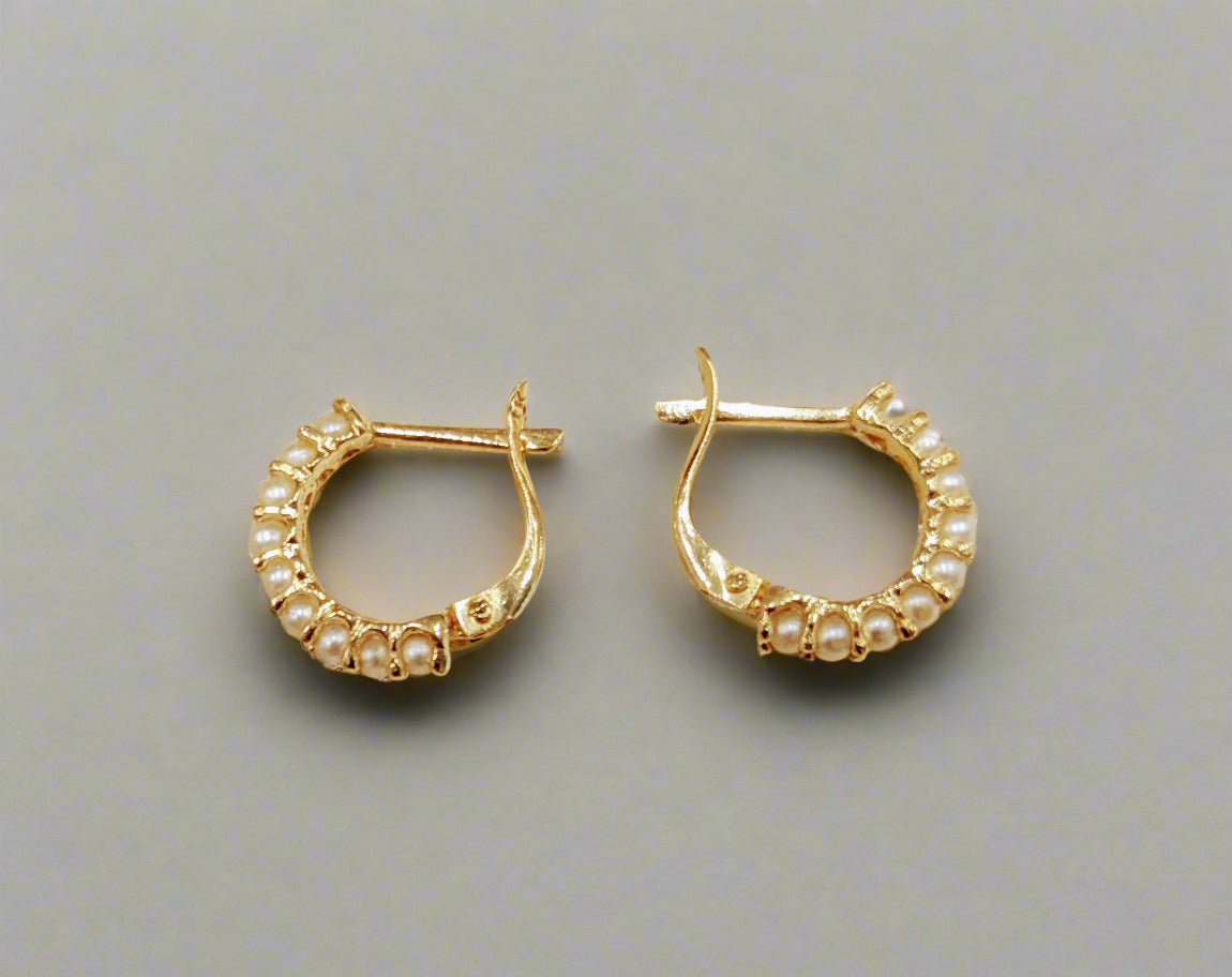 A pair of 14 KT gold hoop earrings with seed pearls and locking backs, displayed against a white background.