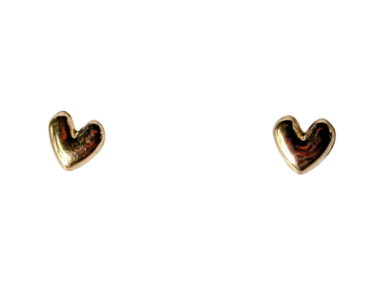 A pair of small gold heart stud earrings on a textured white surface.