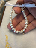 14 KT Mindy Harris Pearl bracelet with gold cross charm. Finished with lobster claps and polished beads. 