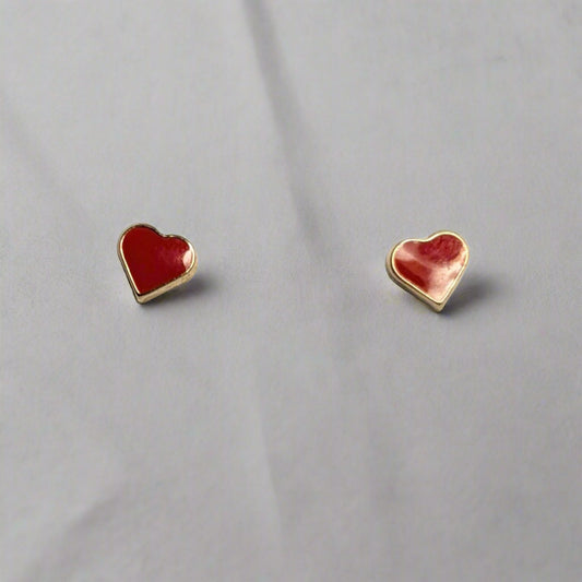 A pair of 14 KT gold children's heart-shaped screw back earrings with red enamel, displayed in a white box.
