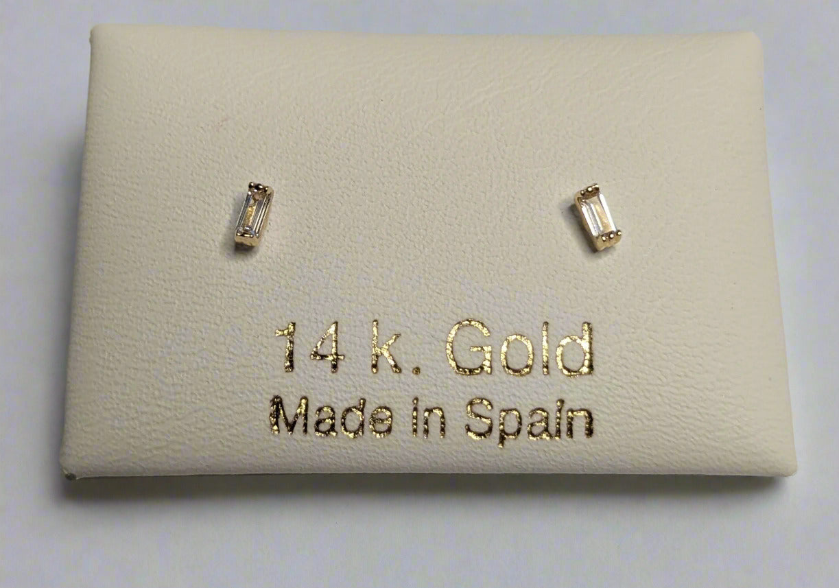 A pair of 14 KT gold earrings with baguette cuts, displayed on a white card with '14 k. Gold Made in Spain' printed on it.